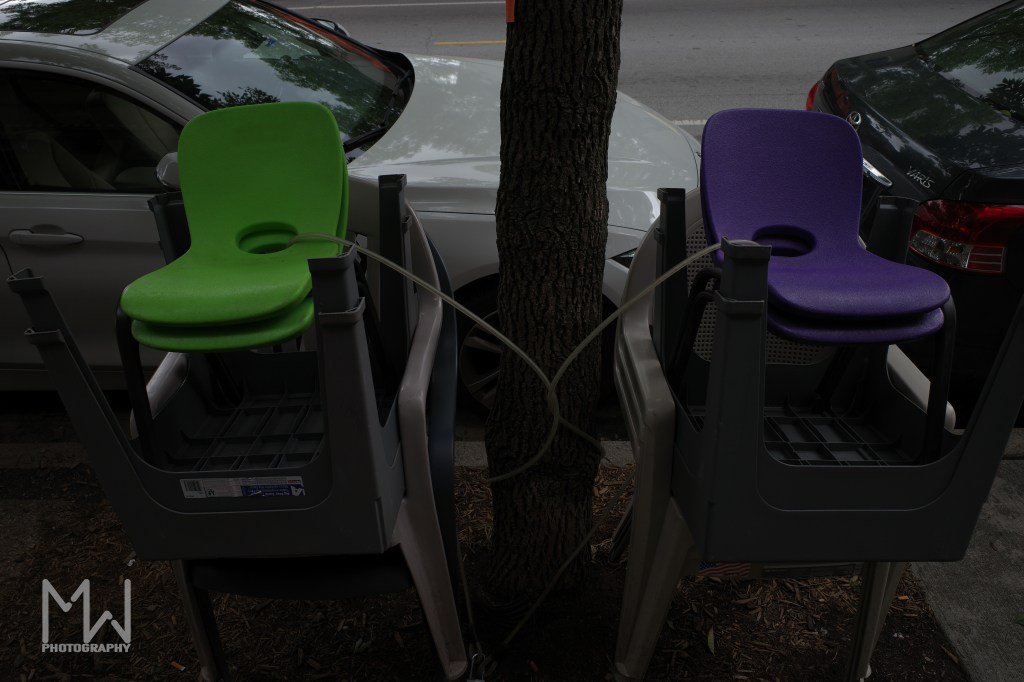 Photo of a green and purple chair locked up to a tree